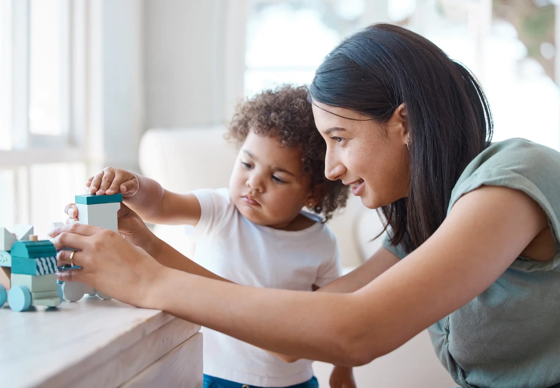 Shot of a young mother and daughter playing with a toy at home